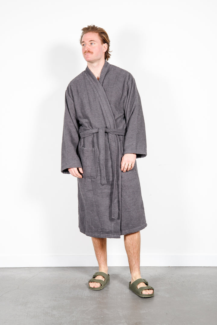 man wearing mid length dark grey cotton terry relaxed fit spa robe #colour_charcoal