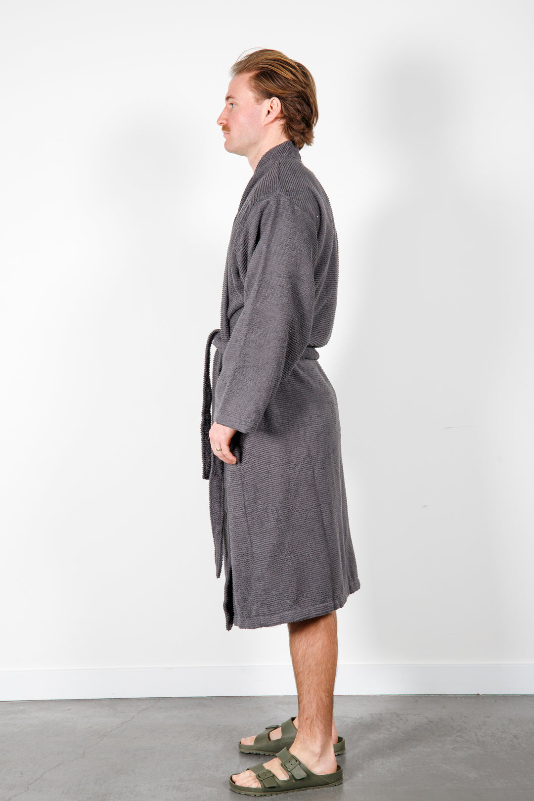 man wearing mid length dark grey cotton terry relaxed fit spa robe #colour_charcoal