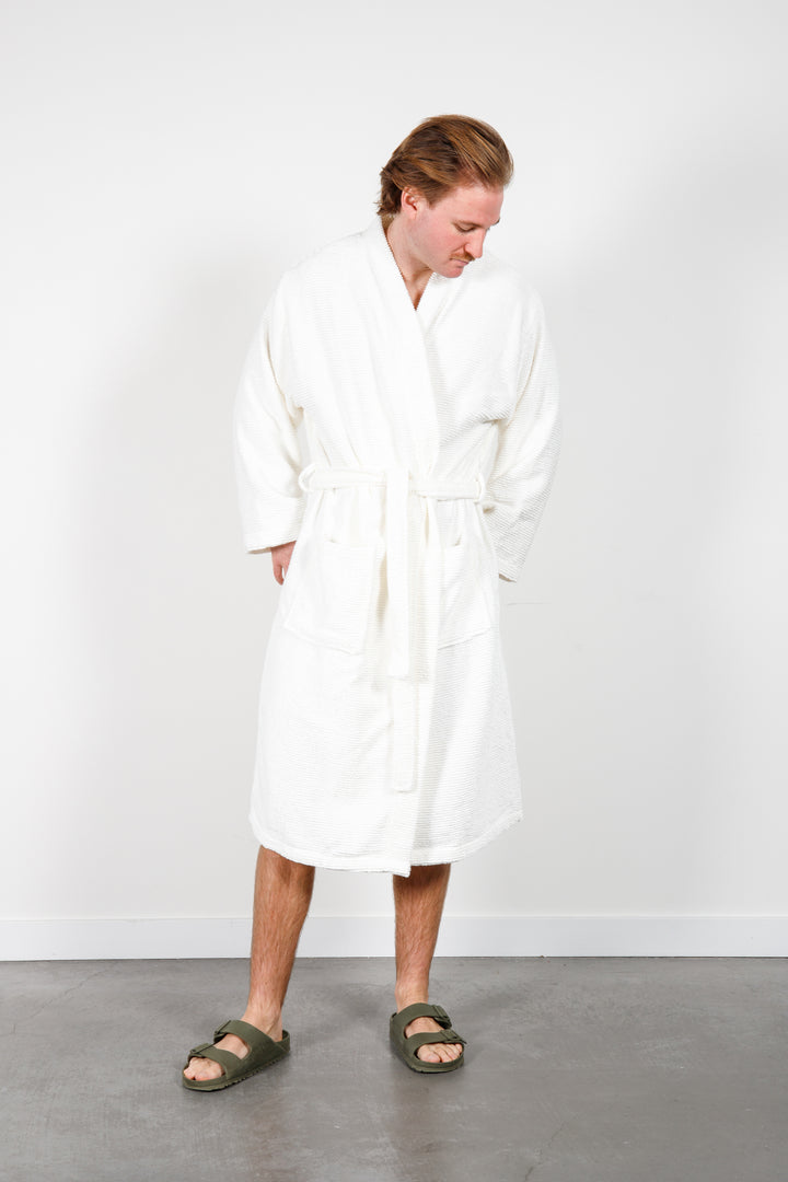 man wearing mid length white cotton terry relaxed fit spa robe #colour_off-white