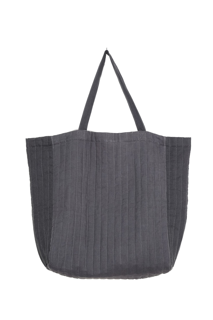 An oversized quilted grey tote bag with zipper closure and shoulder straps.