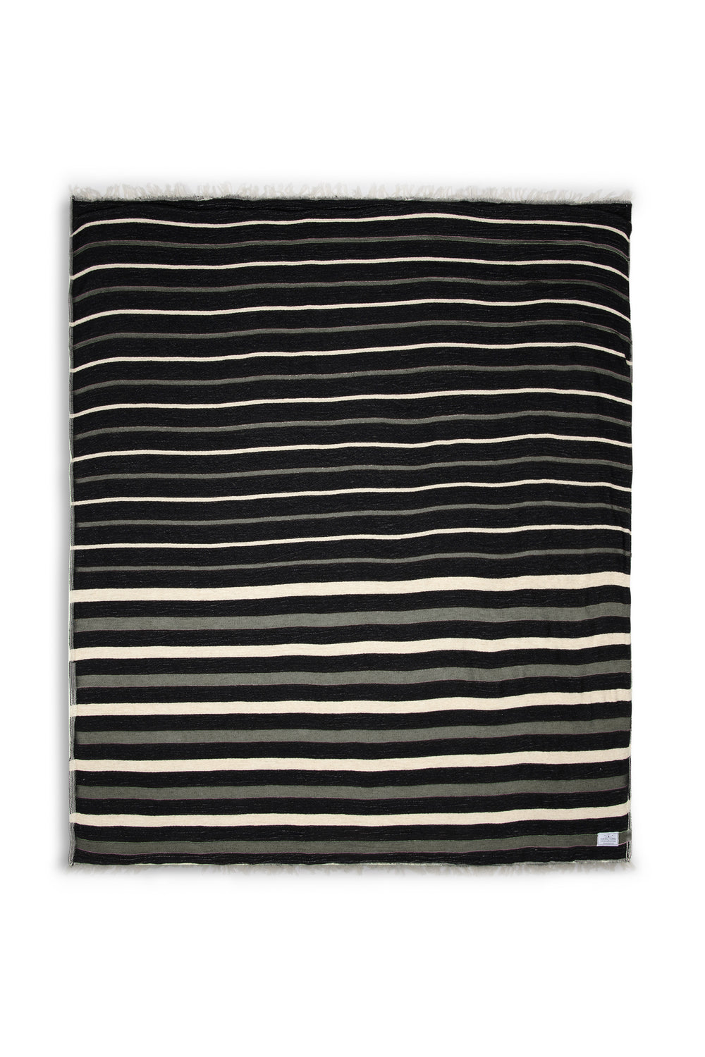 Black blanket with eyelash fringe and cream and grey stripes laid flat on a white background