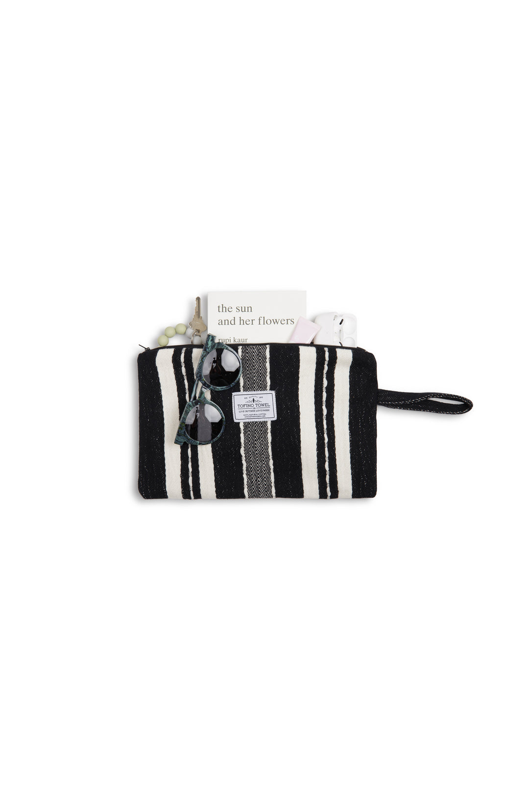 Black zip up pouch with white stripes and a wrist handle containing sunglasses and accessories on a white background