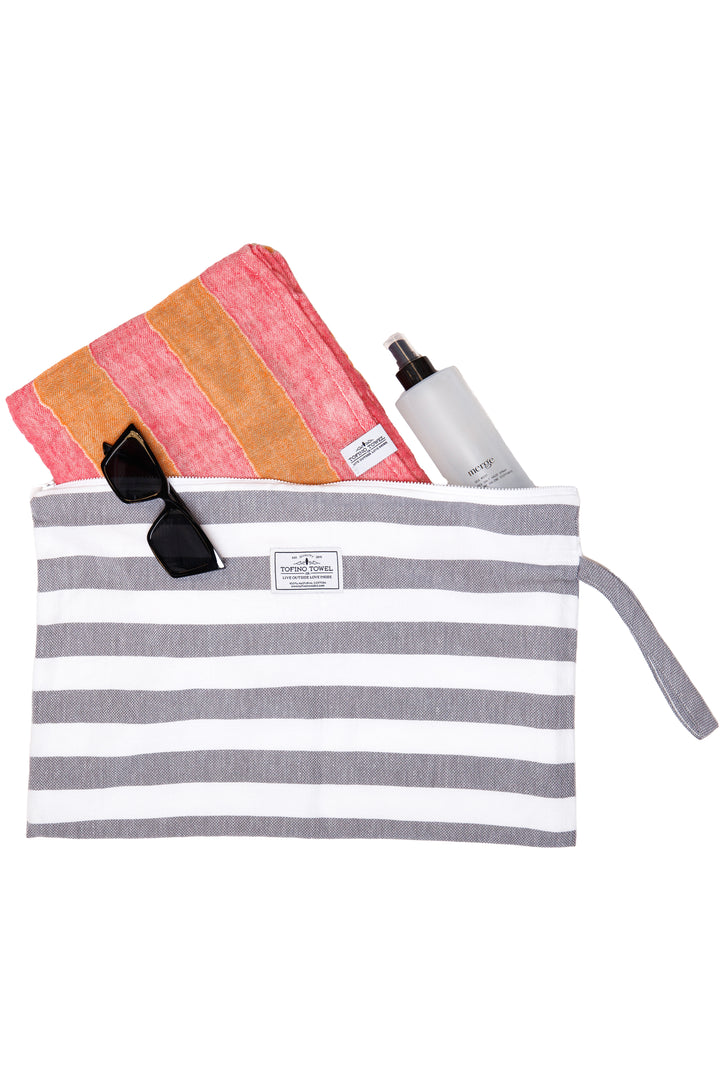 large white and grey striped zip up pouch with wrist handle containing accessories on a white background #colour_grey-stripes
