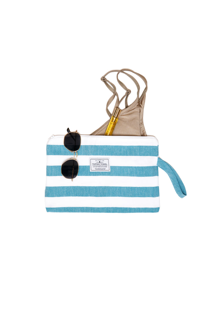 small white and teal blue striped zip up pouch with wrist handle containing accessories on a white background #colour_aqua-stripes