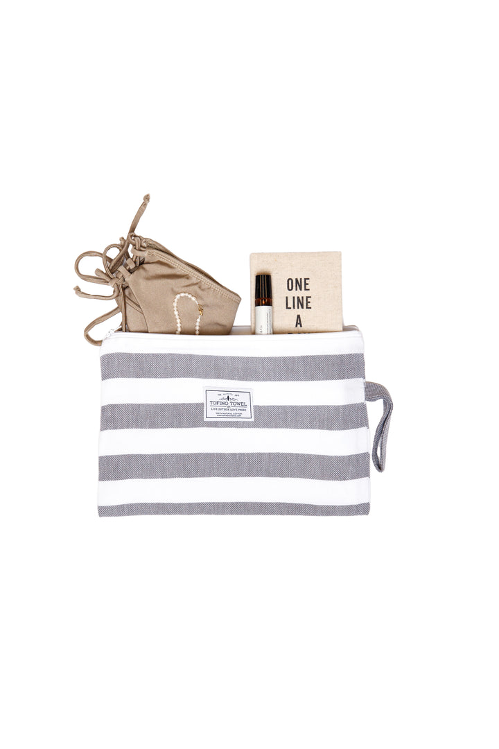 small white and grey striped zip up pouch with wrist handle containing accessories on a white background #colour_grey-stripes