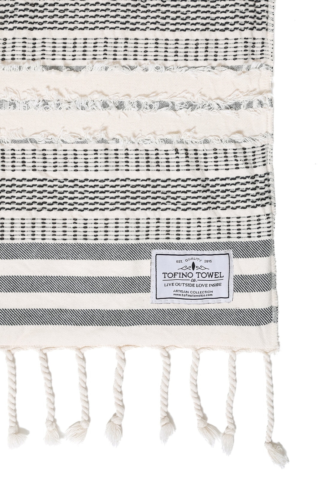 close up of cream and black fleece lined throw with textured stripes and tassels on a white background 
 #colour_black-stripe