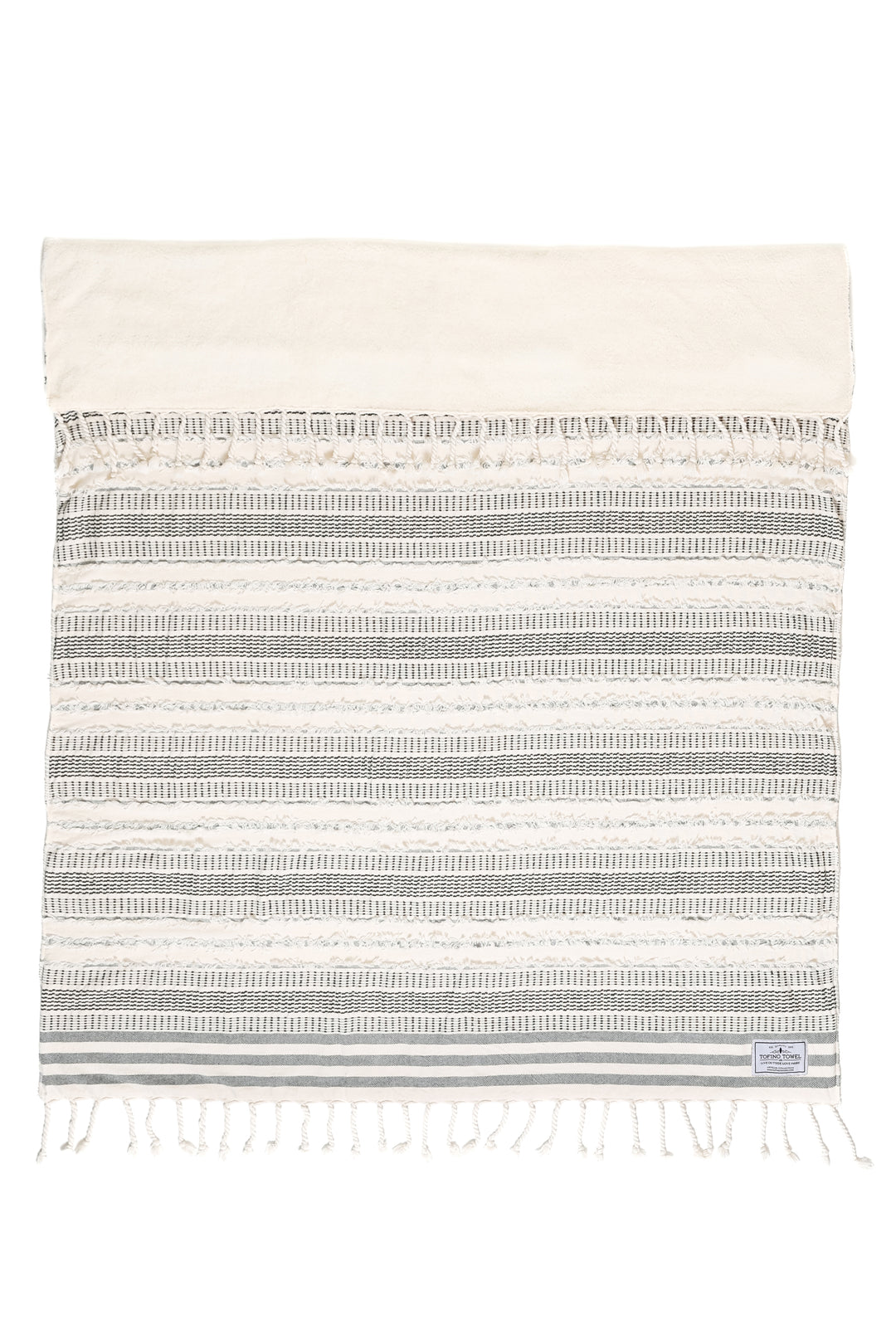 cream and black fleece lined throw with textured stripes and tassels laid flat with one side folded back on a white background #colour_black-stripe