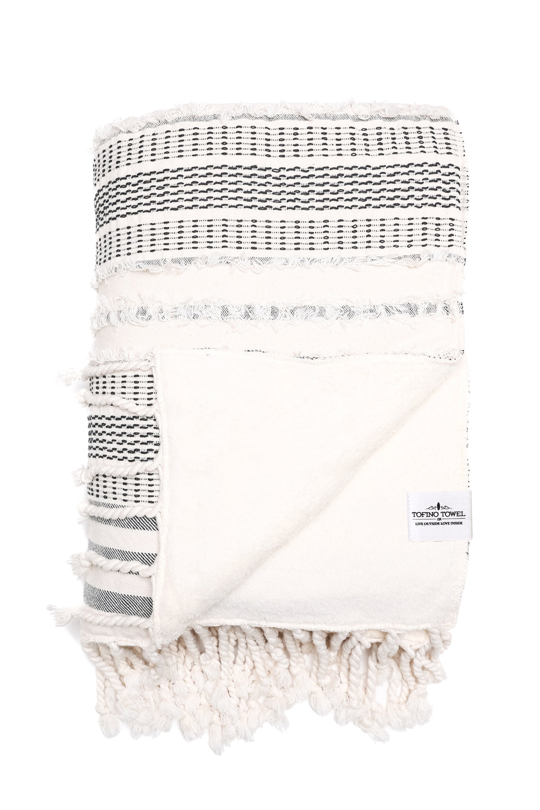 cream and black fleece lined throw with textured stripes and tassels folded with one corner turned back on a white background  #colour_black-stripe