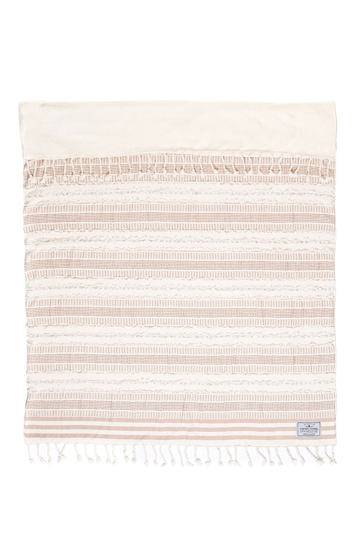 cream and light brown fleece lined throw with textured stripes and tassels laid flat with one side folded back on a white background #colour_camel-stripe