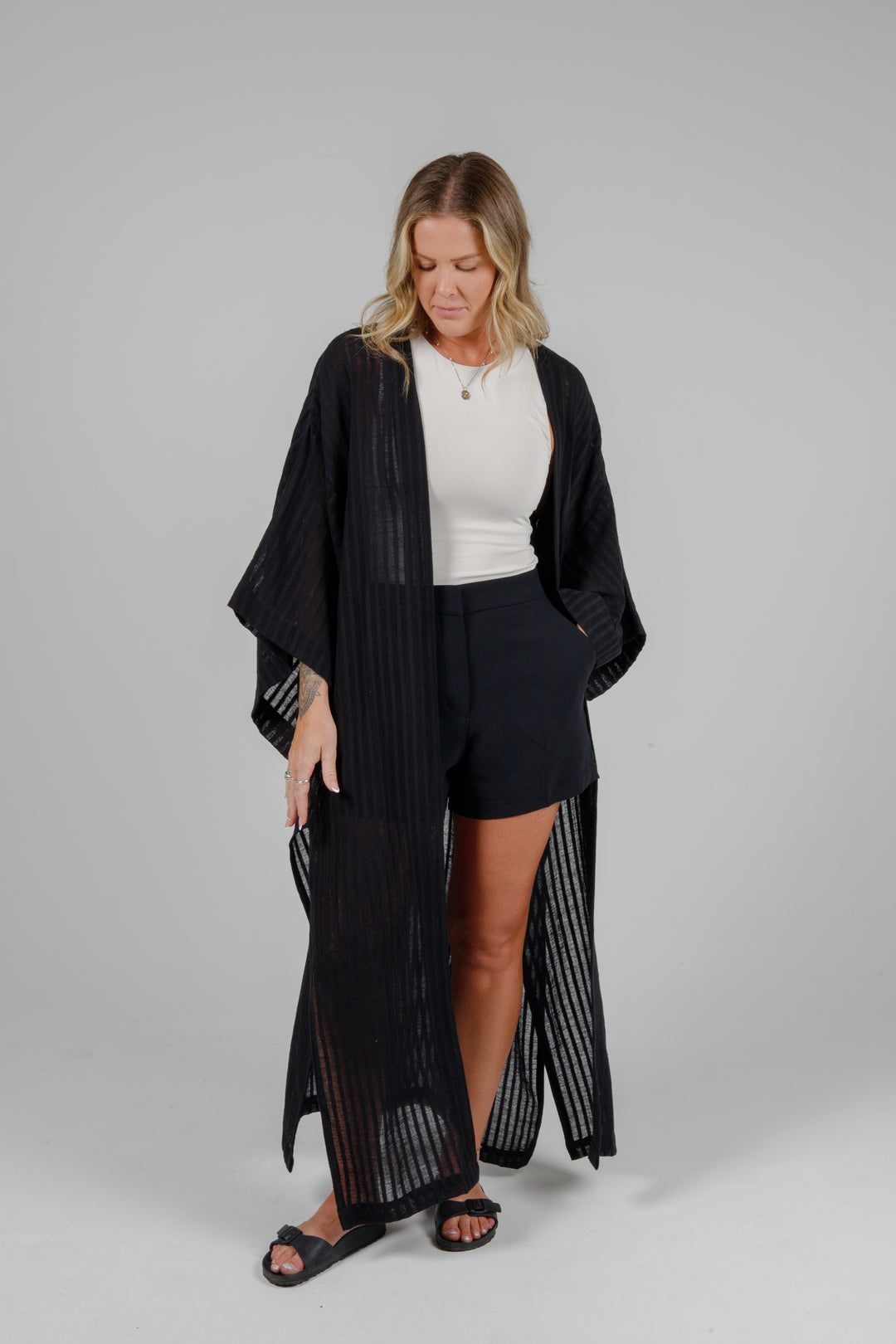 Long black semi-sheer linen blend cover-up with wide kimono sleeves and side slits, full-length lightweight beach kimono layered over neutral outfit for resort wear style