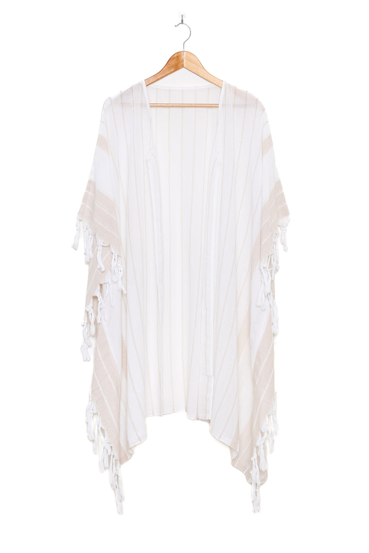 A white open cover-up with subtle stripes and tassels, on a hanger against a white background
