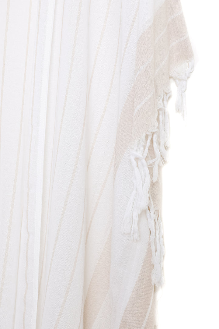 A close up of white open cover-up with subtle stripes and tassels against a white background