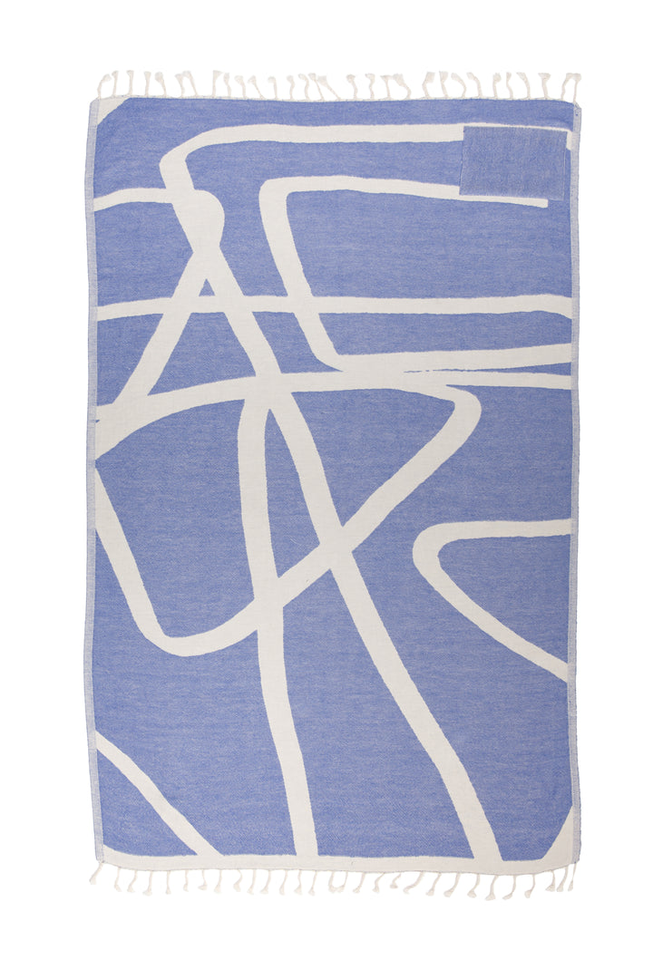 Turkish cotton towel with an abstract white and blue design. eyelash fringe and discreet zipper pocket laid flat on a white background #colour_blue