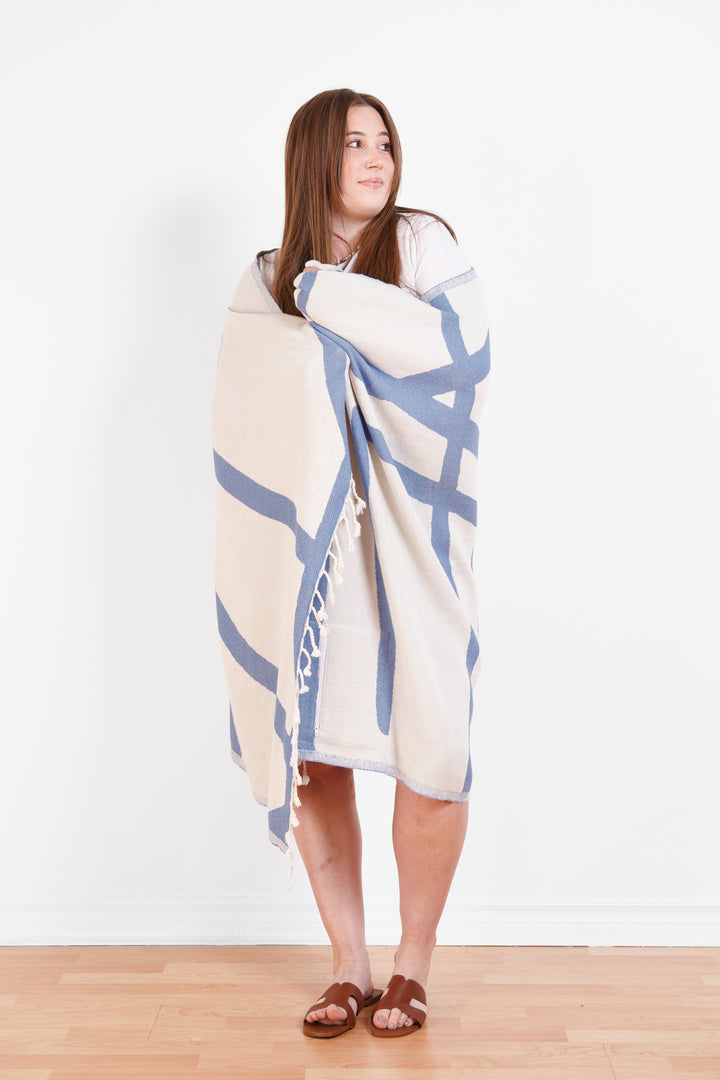 model wrapped in a Turkish cotton towel with an abstract white and blue design and eyelash fringe and on a white background #colour_blue