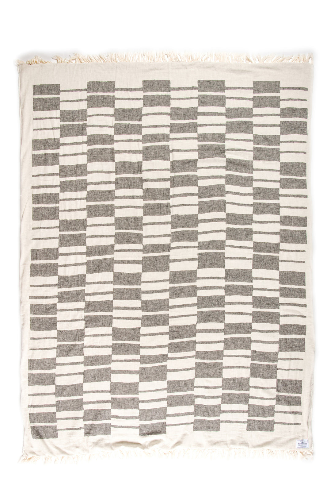 off white and dark grey fleece lined throw with modern checker board pattern and eyelash fringe laid flat on a white background #colour_granite