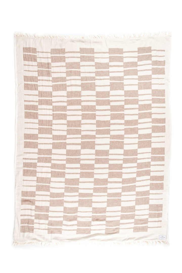 off white and light brown fleece lined throw with modern checker board pattern and eyelash fringe laid flat on a white background #colour_walnut