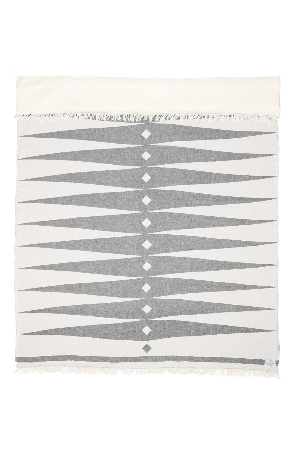 off white fleece lined throw with dark grey geometric design and eyelash fringe laid flat with one side folded down on a white background #colour_whitecap