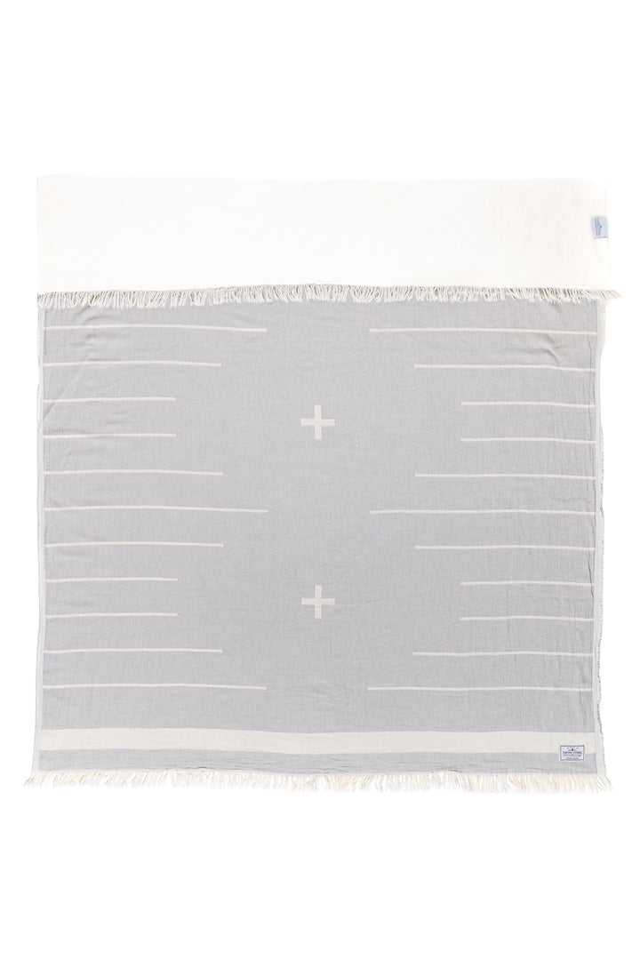 light grey and white fleece lined throw in a minimal modern design with eyelash fringe laid flat with one side folded down on a white background #colour_pewter