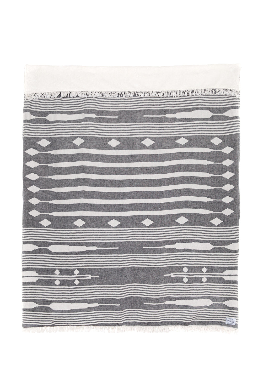 dark grey and cream traditional geometric, fleece lined throw with eyelash fringe on laid flat with one side folded down on white background #colour_granite