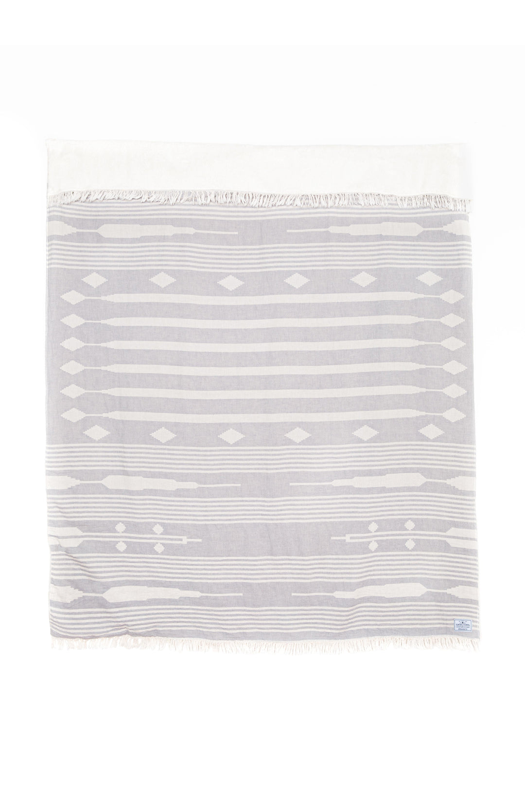 light grey and white traditional geometric pattern fleece lined throw with eyelash fringe laid flat with one side folded over on a white background #colour_pewter