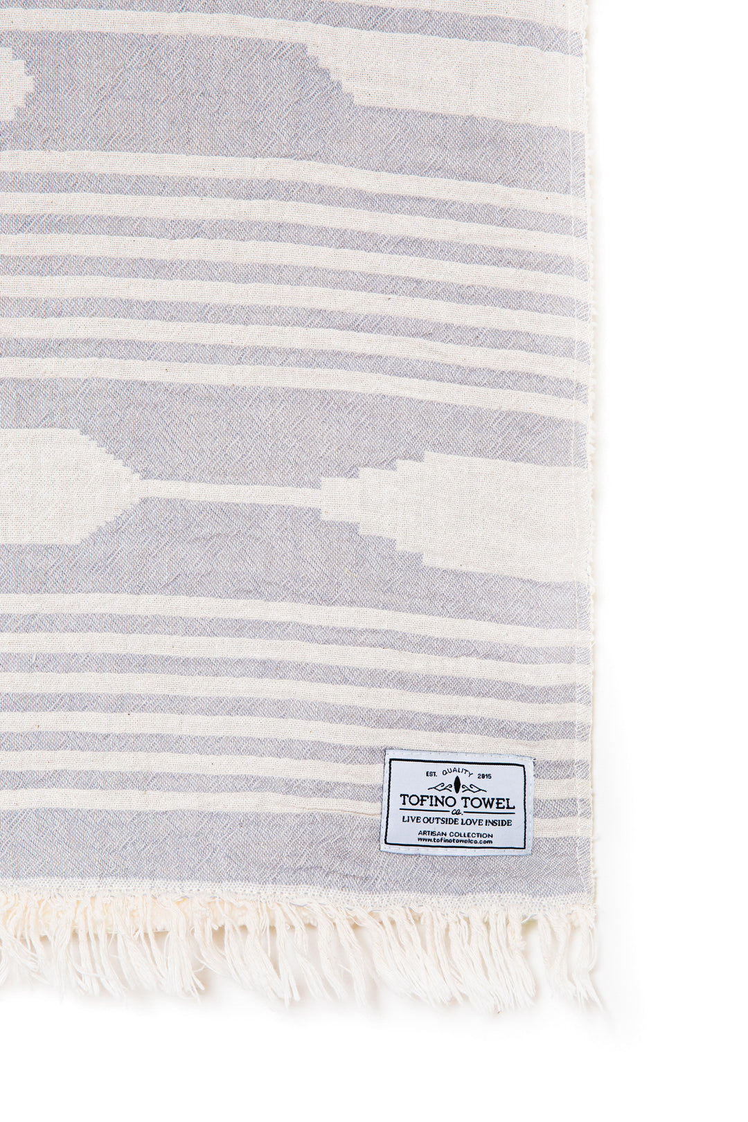 light grey and white traditional geometric pattern fleece lined throw close up of corner and eyelash fringe with tofino towel co label on a white background #colour_pewter