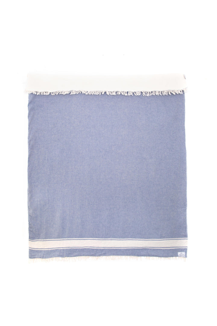 A denim-blue coloured fleece-lined Turkish throw with eyelash fringe, and simple stylized white stripe #colour_sky