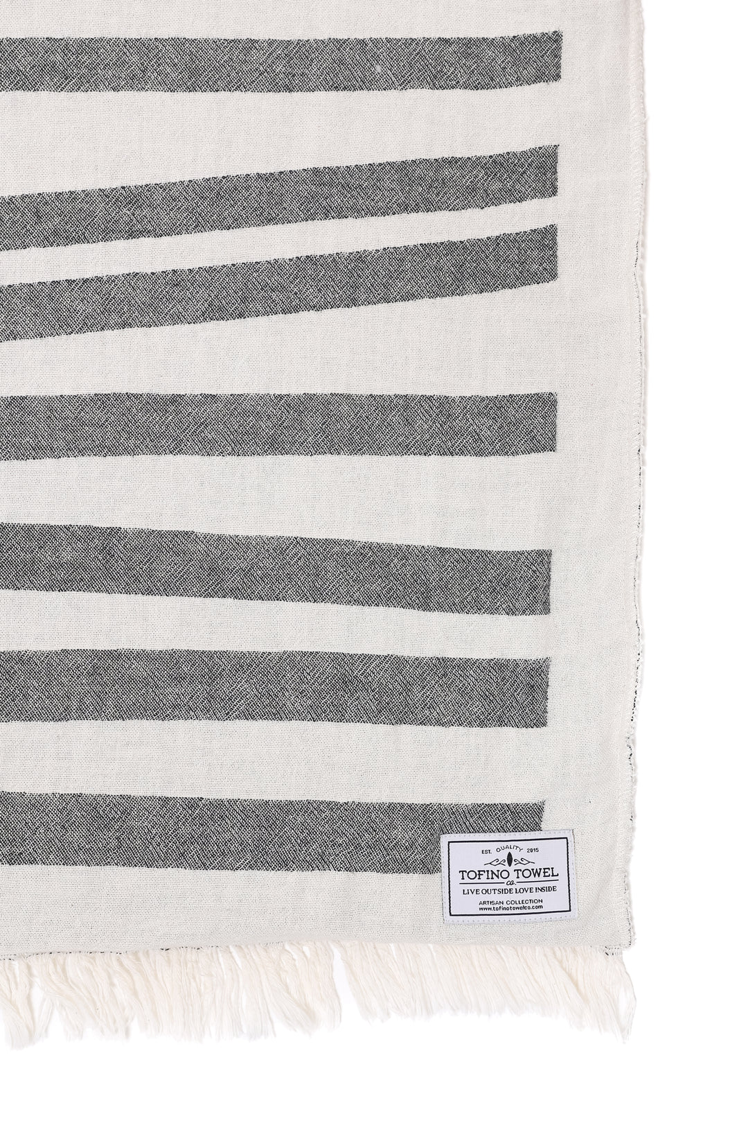 close up of off white and dark grey fleece lined throw with modern ripple effect stripe design with eyelash fringe a white background #colour_granite