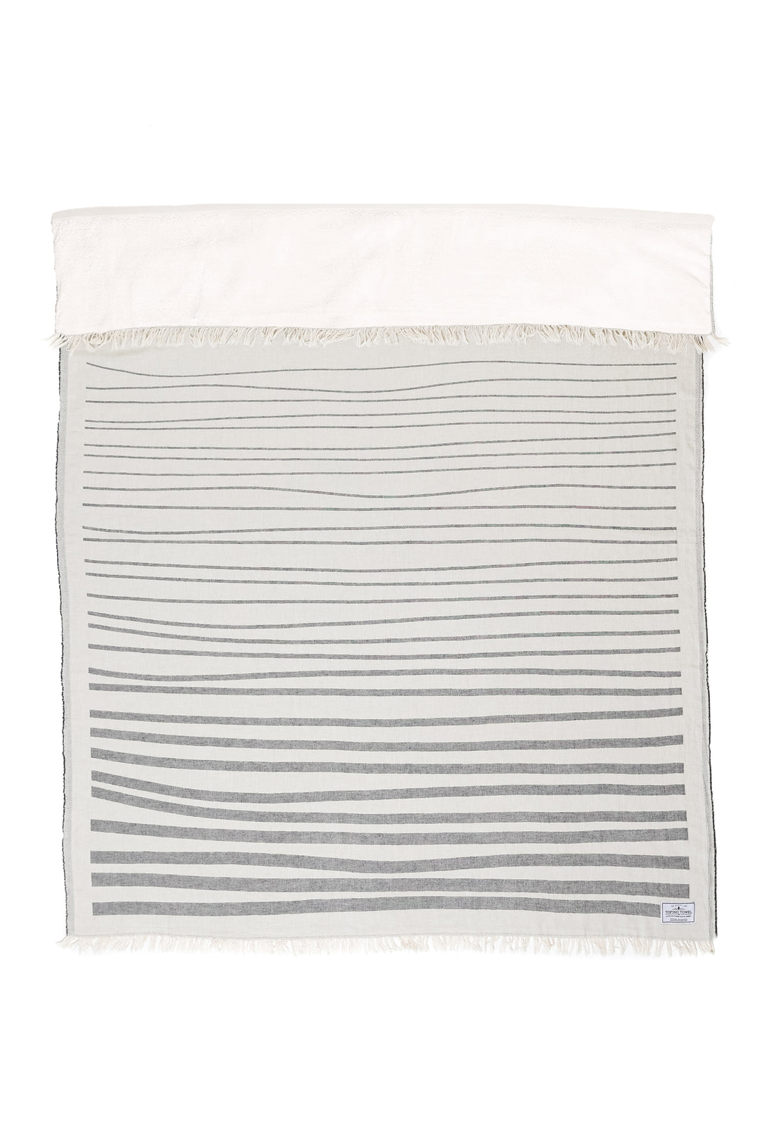 off white and dark grey fleece lined throw with modern ripple effect stripe design with eyelash fringe laid flat with one side folded down on a white background #colour_granite